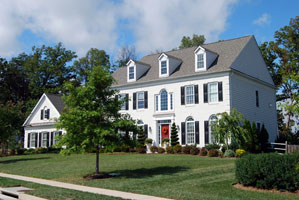 A good condition American style White house with pruned trees and bushes after well maintained property in the warmer season in Darien